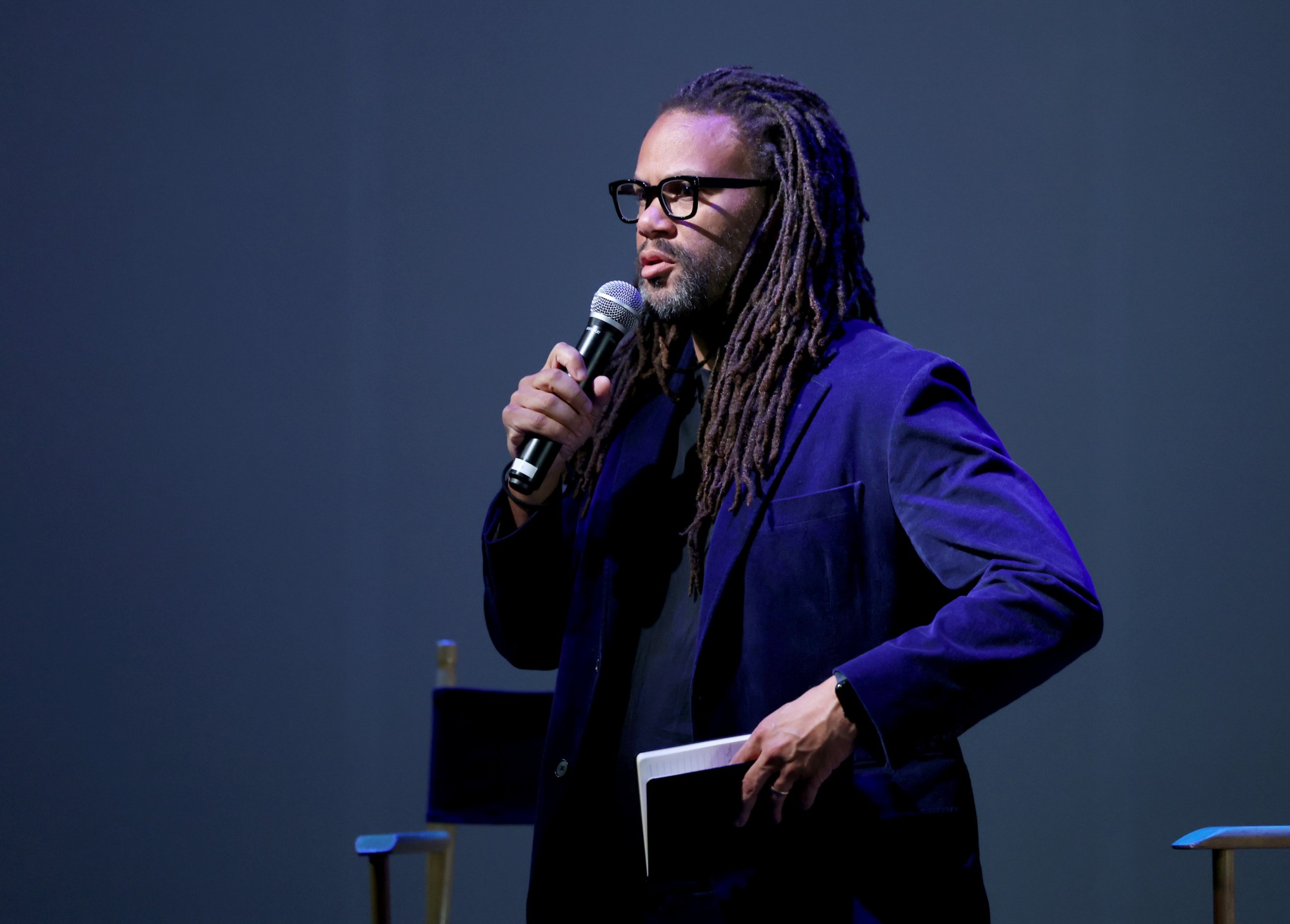 Franklin Leonard on stage with a microphone and a set of cards, moderating a Q&A
